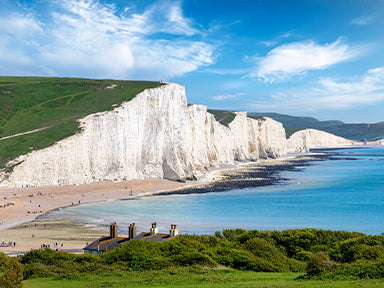 Seven Sisters chalk cliffs on the East Sussex coast, with a blue sky and sea